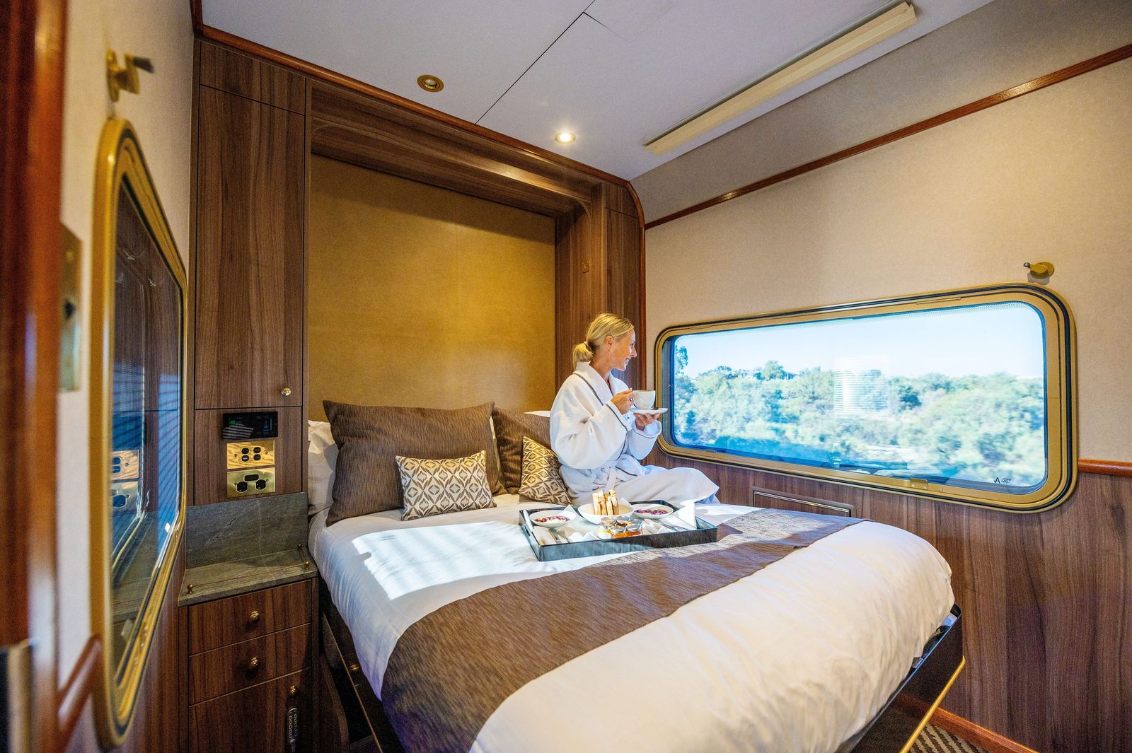 A guest relaxing in a private cabin on The Ghan. Photo: Tourism Australia