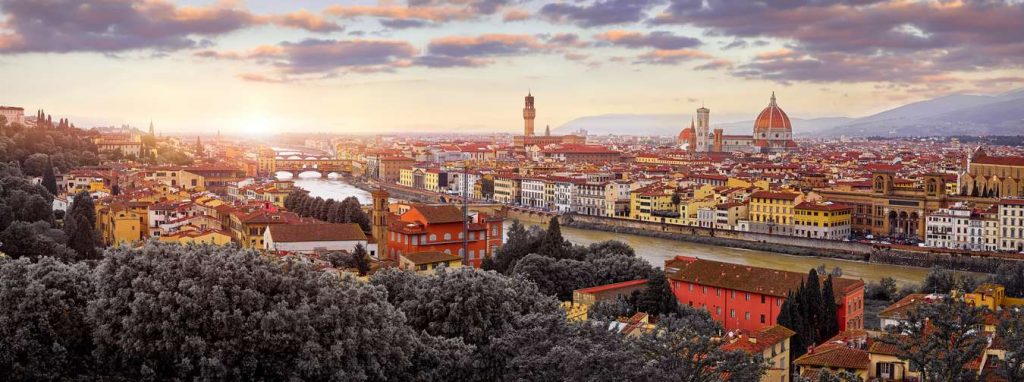 Panoramic view of Florence, Italy at sunset with the Arno River flowing through the city.