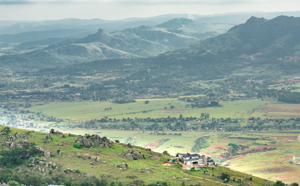 Ezulwini valley in Swaziland with beautiful mountains, trees and rocks in scenic green valley between Mbabane and Manzini cities. Traditional huts houses of Swaziland