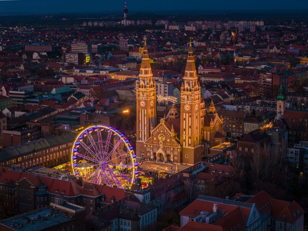 Szeged, Hungary, Giant christmas market at next to Szeged cathedral. Hungarian foods, drinks, presents and gifts. Giant labirintyh and ferris whhel for children