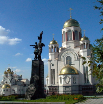White and gold Church on Blood in Yekaterinburg, Russia, with a dark monument in the foreground.