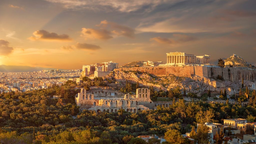 Golden sunset illuminates Athens, Greece, showcasing the Acropolis, ancient ruins, and cityscape. Warm colors and dramatic lighting.