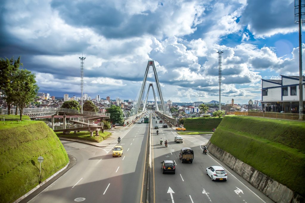 Wide angle view of the cable-stayed bridge in Pereira, Colombia, with traffic and cloudy sky.