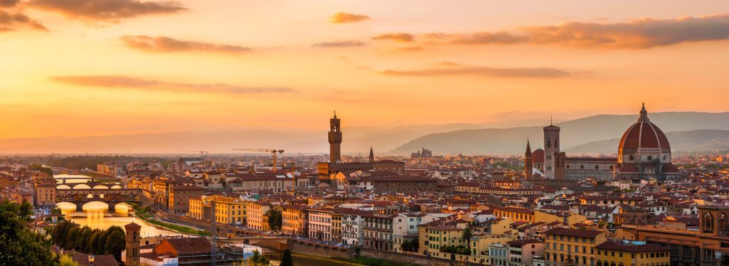 Panoramic view of Florence, Italy at sunset. The Arno River flows under the Ponte Vecchio bridge.