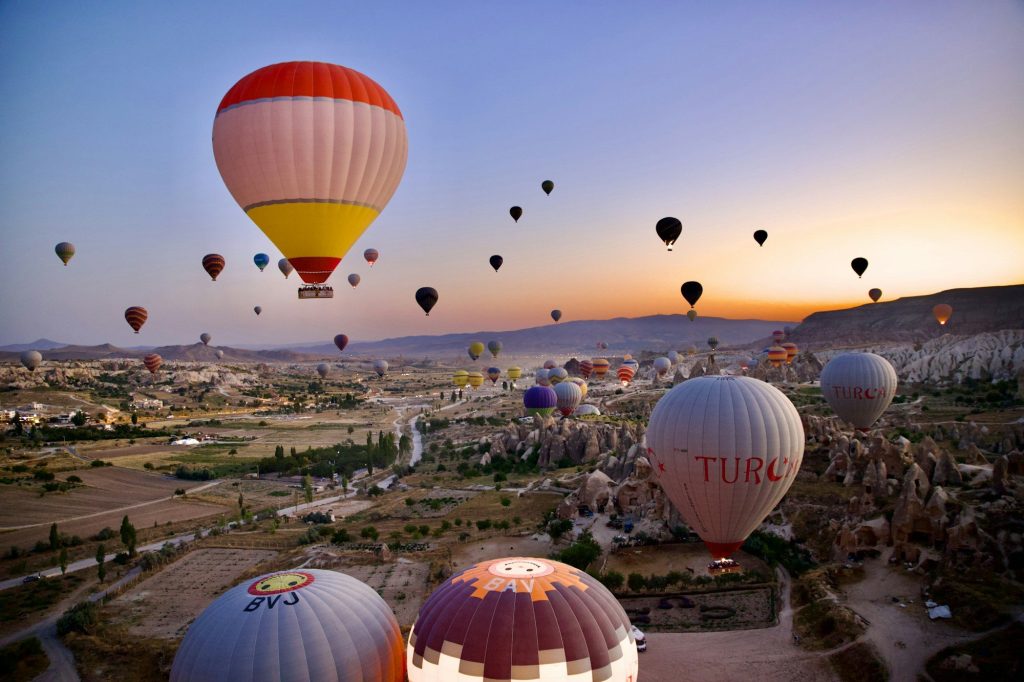 Hot-air balloons drifting over the valleys of Cappadocia, Turkey, at sunrise.