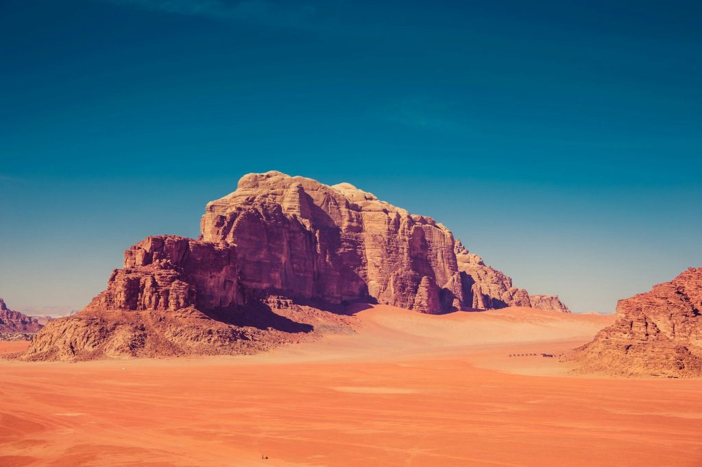 Sandstone mountains rising from the red sands of Wadi Rum, Jordan
